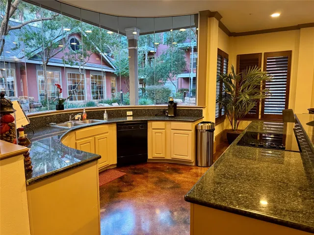 a kitchen with stainless steel appliances granite countertop a sink a stove and a wooden floors