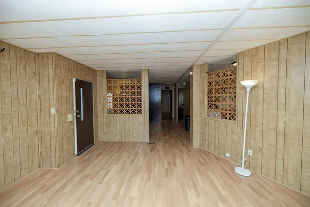 a view of a hallway with wooden floor and closet