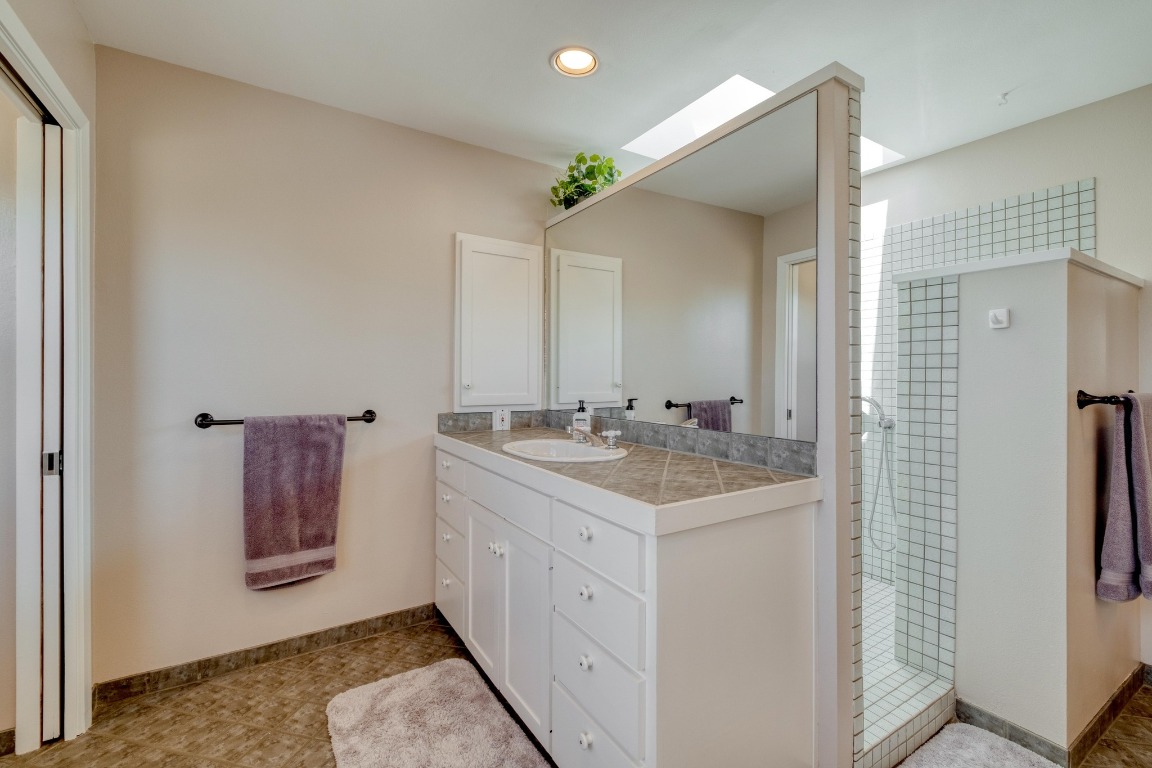 7600 Deer Run Road Leander, TX 78641 - Photo 20 of 39 a bathroom with a double vanity sink and mirror
