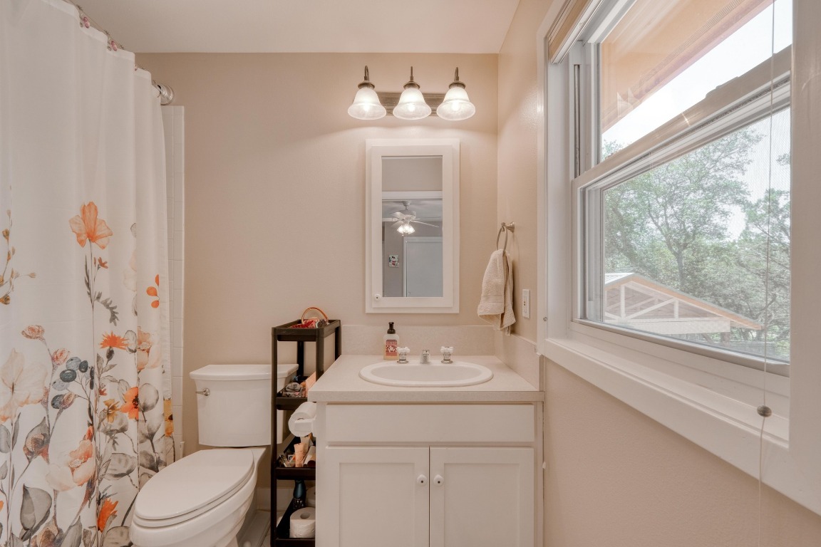 7600 Deer Run Road Leander, TX 78641 - Photo 24 of 39 a bathroom with a sink a mirror a toilet and a window