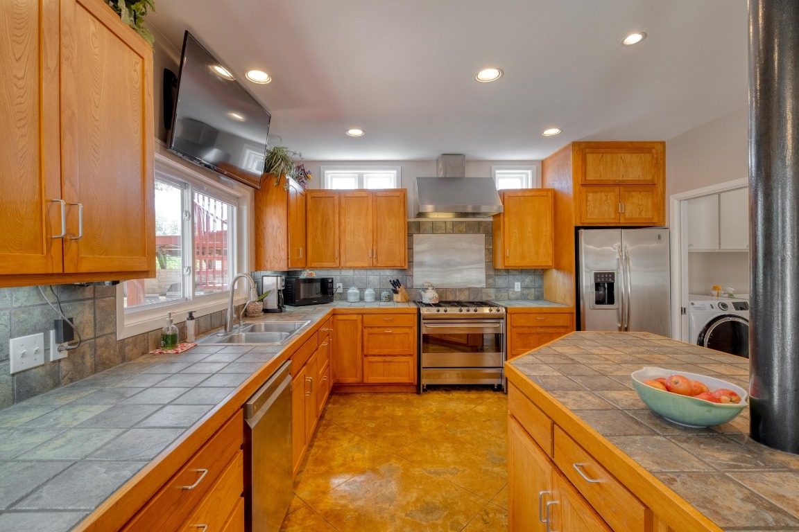 7600 Deer Run Road Leander, TX 78641 - Photo 8 of 39 a large kitchen with stainless steel appliances a large counter top a stove a sink and a refrigerator