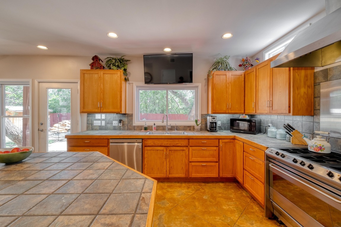 7600 Deer Run Road Leander, TX 78641 - Photo 9 of 39 a large kitchen with stainless steel appliances granite countertop a stove a sink and a microwave