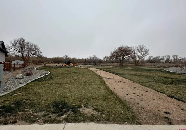 a view of a lake with beach and large trees