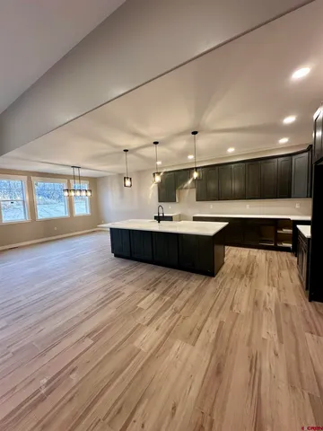 a room with kitchen island stainless steel appliances wooden floor and window