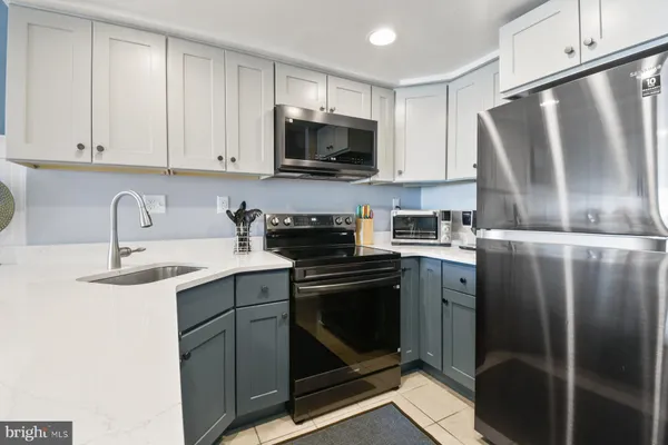 a kitchen with a sink a counter space appliances and cabinets