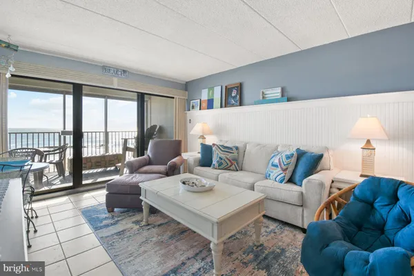 a living room with furniture and a floor to ceiling window