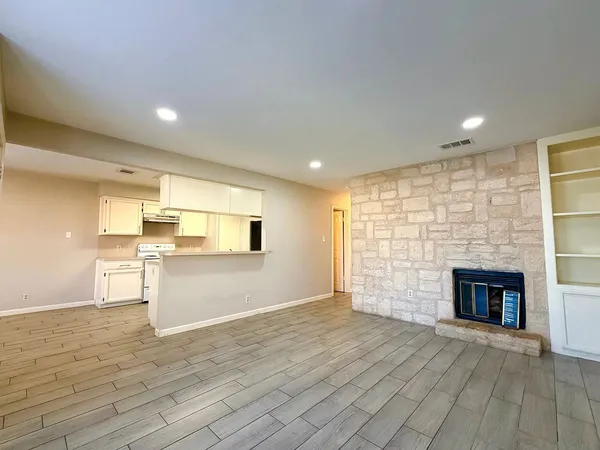 an empty room with wooden floor and fireplace