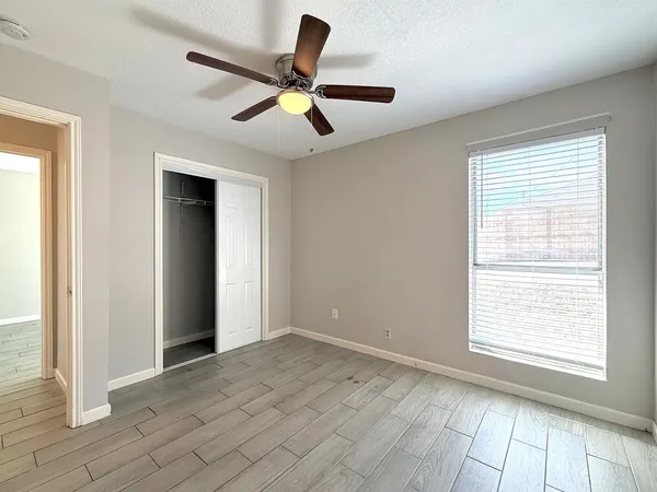 an empty room with wooden floor and windows