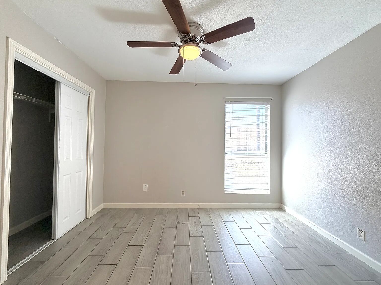 209 East Noton Street, Unit 109 Pflugerville, TX 78660 - Photo 10 of 11 an empty room with wooden floor and windows