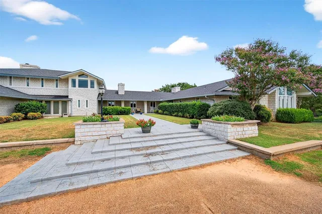 a front view of a house with a yard and potted plants