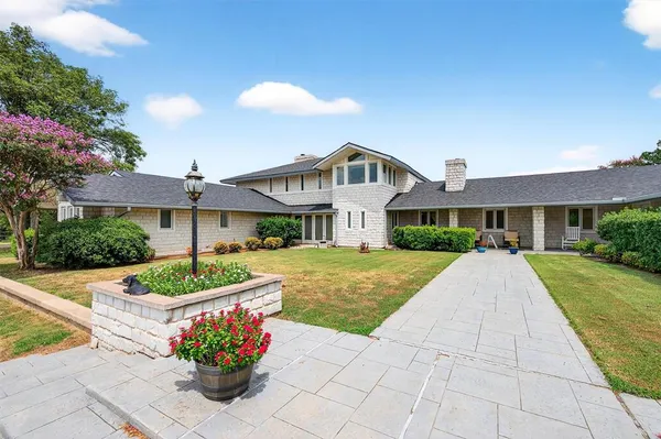 a front view of a house with a yard and potted plants