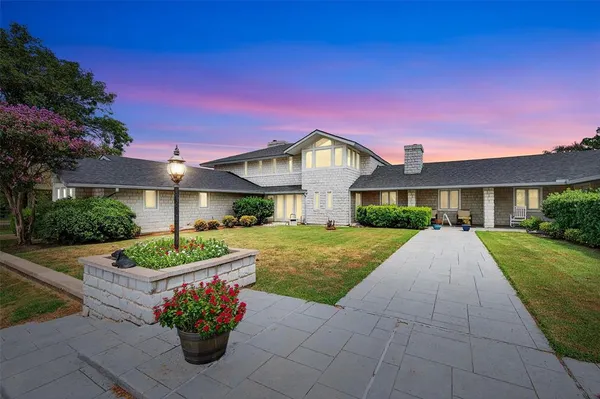 a front view of a house with a yard and seating space