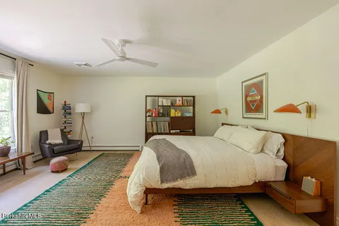 a bedroom with a bed wooden floor and window