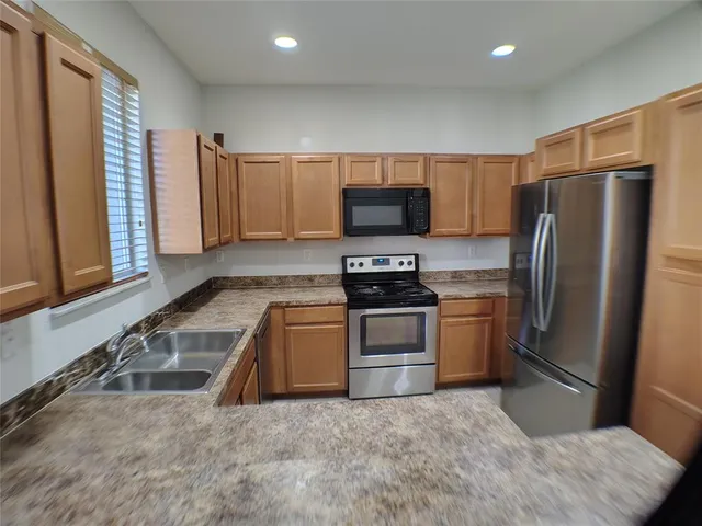 a kitchen with stainless steel appliances a refrigerator stove and microwave