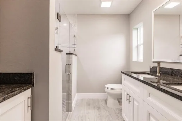 a bathroom with a granite countertop sink toilet and shower