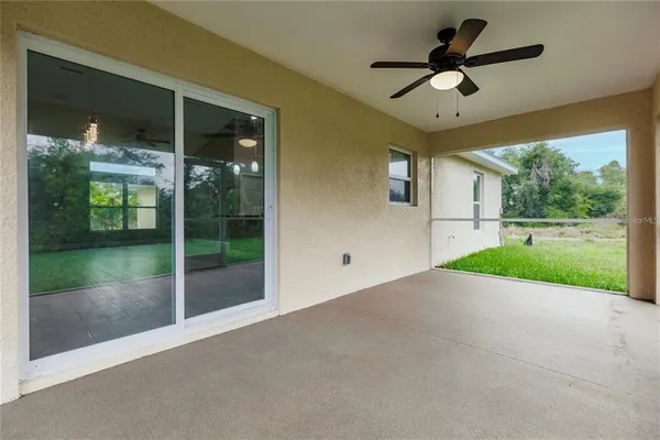 a view of a porch with a floor to ceiling window and a ceiling fan