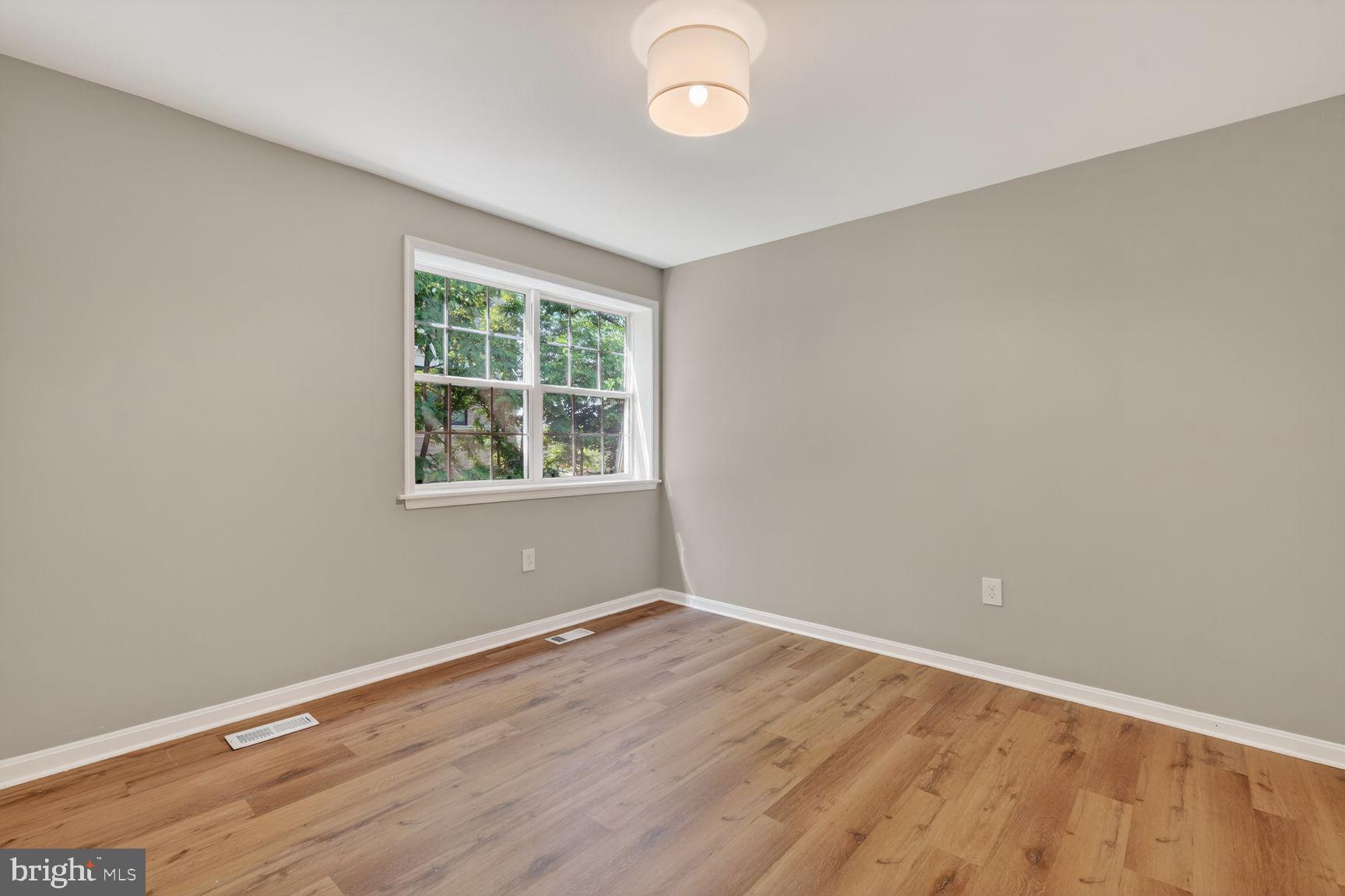 1008 Rittenhouse Street Northwest, Unit 15 Washington, DC 20011 - Photo 35 of 39 an empty room with wooden floor and windows
