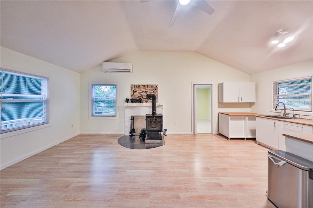 5599 Minks Pond Road Bushkill, PA 18324 - Photo 6 of 64 A vaulted ceiling living area with hardwood flooring and a cozy fireplace creates a warm, open ambiance.