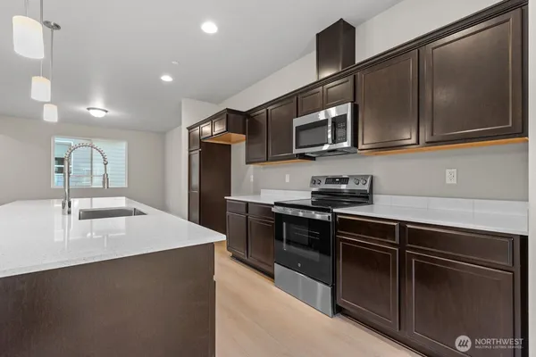 a kitchen with stainless steel appliances granite countertop a sink and a stove