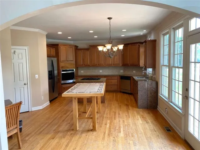 a kitchen with stainless steel appliances granite countertop a stove a sink dishwasher and a refrigerator