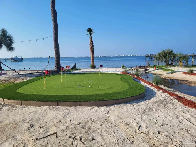 a view of a ocean with a big yard and palm trees