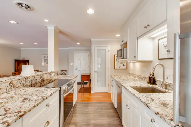 a large kitchen with stainless steel appliances granite countertop a sink and cabinets