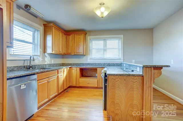 a kitchen with stainless steel appliances granite countertop a sink and a stove