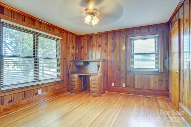 a view of an empty room with a window and wooden floor