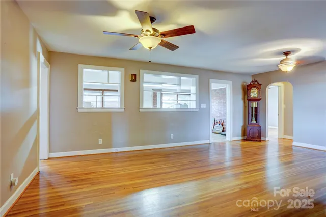 a view of an empty room with window and wooden floor