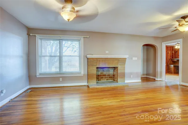 wooden floor fireplace and windows in an empty room