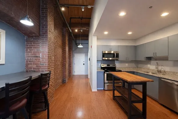 a kitchen with granite countertop a stove a sink and a refrigerator