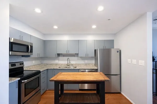 a kitchen with stainless steel appliances granite countertop a refrigerator a stove microwave and sink