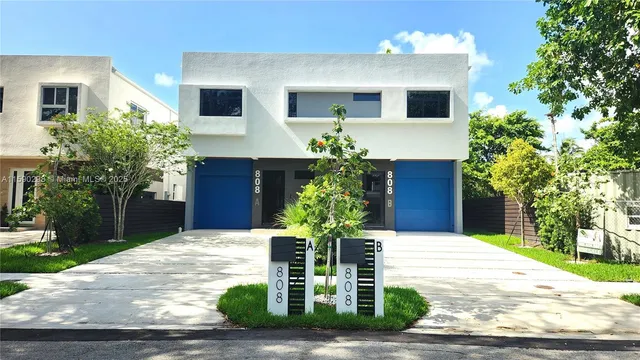 a view of a house with yard and potted plants