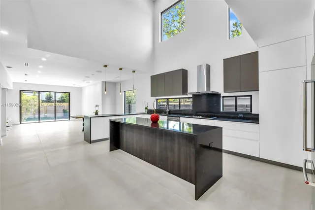 a living room with stainless steel appliances kitchen island furniture and a flat screen tv