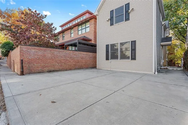 an empty room with wooden floor a ceiling fan a fireplace and windows
