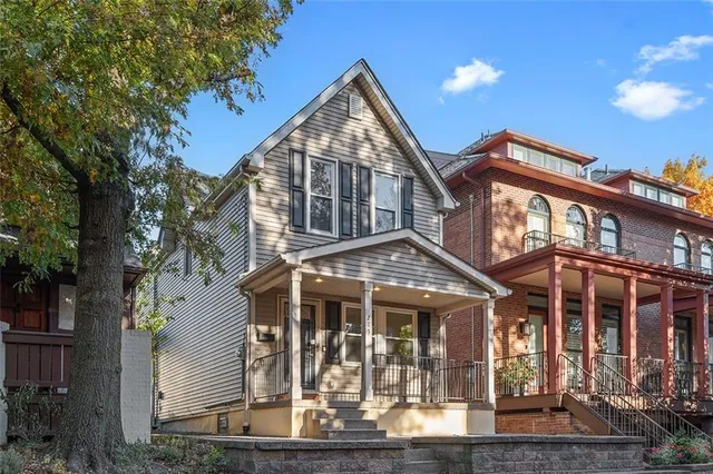 a front view of a house with glass windows and ceiling tree