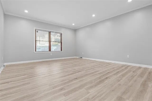 a view of empty room with wooden floor