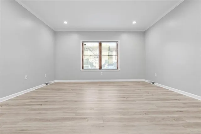 a view of empty room with wooden floor