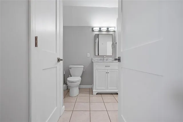 an empty room with wooden floor chandelier fan and windows
