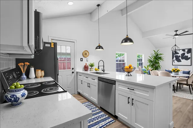 a kitchen with stainless steel appliances granite countertop a sink stove and cabinets