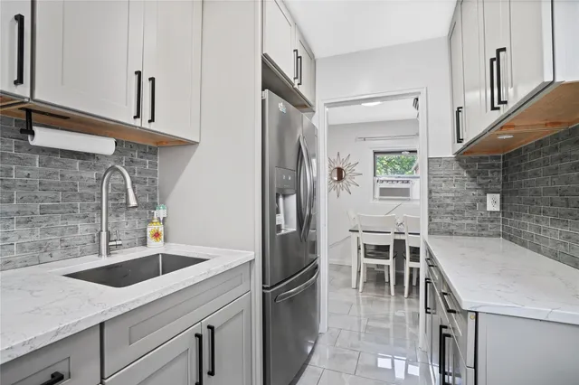 a kitchen with stainless steel appliances granite countertop a sink and a refrigerator