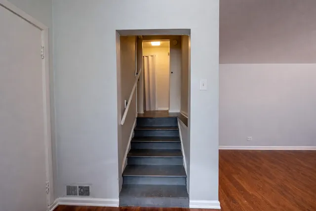 a view of a hallway with wooden floor and entryway