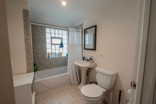 a bedroom with a bed and a lamp on dresser