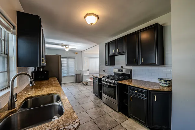 a kitchen with stainless steel appliances granite countertop a refrigerator and a sink