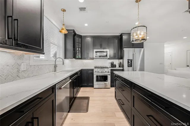 a large kitchen with stainless steel appliances granite countertop a sink counter space a stove and cabinets