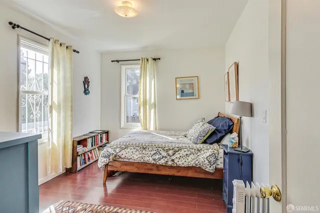 a bed sitting in a bedroom next to a window