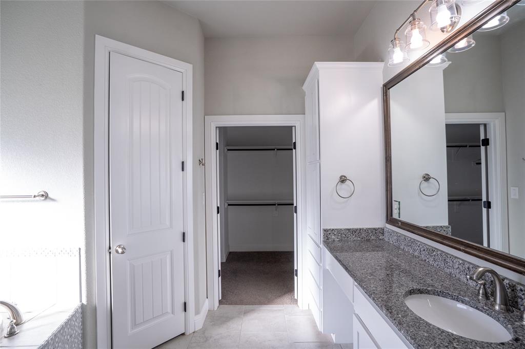 181 Fairview Court Decatur, TX 76234 - Photo 19 of 35 a bathroom with a granite countertop sink shower and a mirror