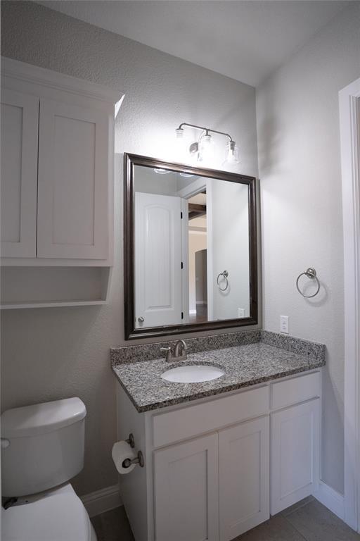 181 Fairview Court Decatur, TX 76234 - Photo 30 of 35 a bathroom with a granite countertop toilet sink and mirror