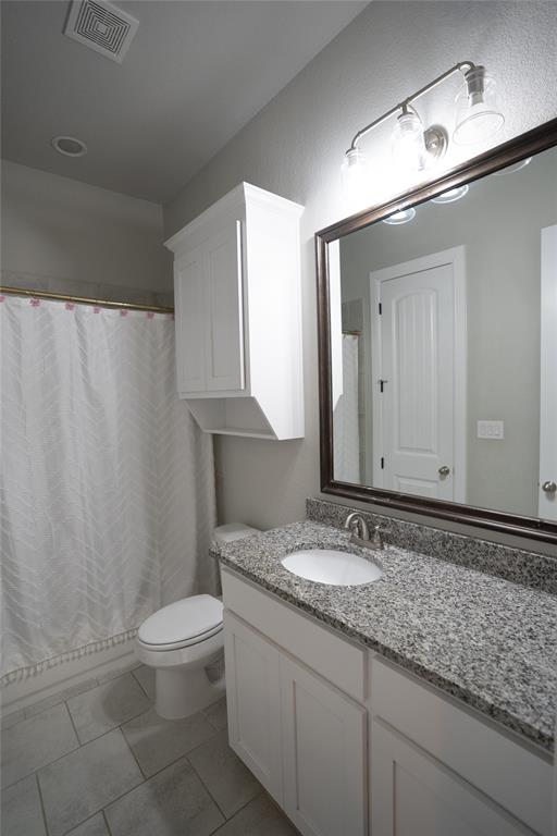181 Fairview Court Decatur, TX 76234 - Photo 31 of 35 a bathroom with a granite countertop sink a toilet and a mirror