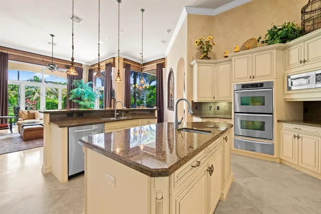 a kitchen with stainless steel appliances granite countertop a sink a stove and a wooden floors